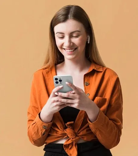 Mulher em pé com fones de ouvido digitando no celular